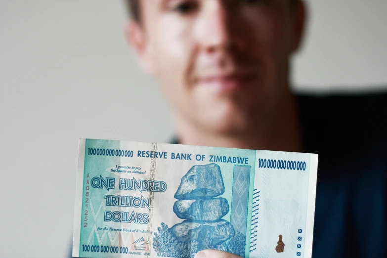 a man holding up an old bank note
