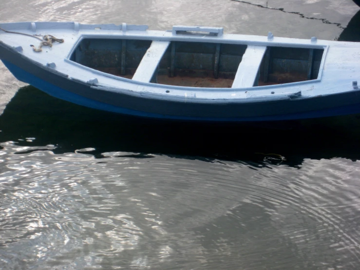 a small blue boat floats on the water