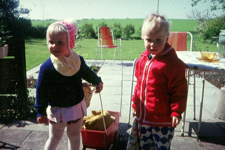 two children with bags on a patio patio