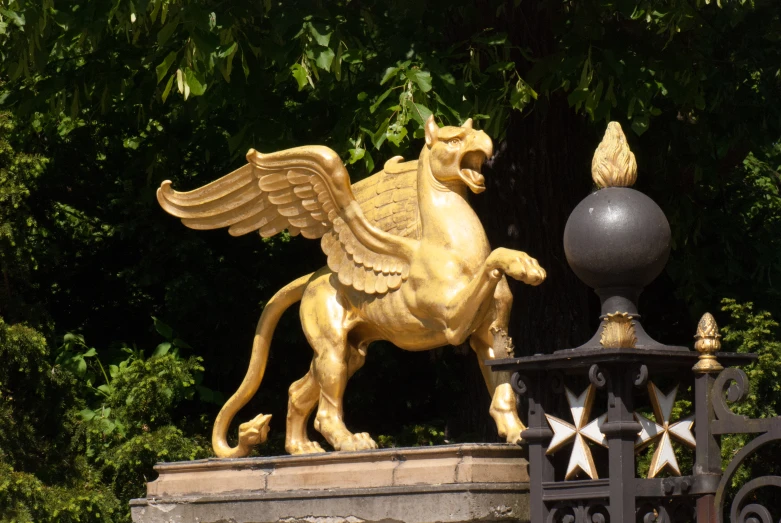 a gold statue of a horse on top of a fence