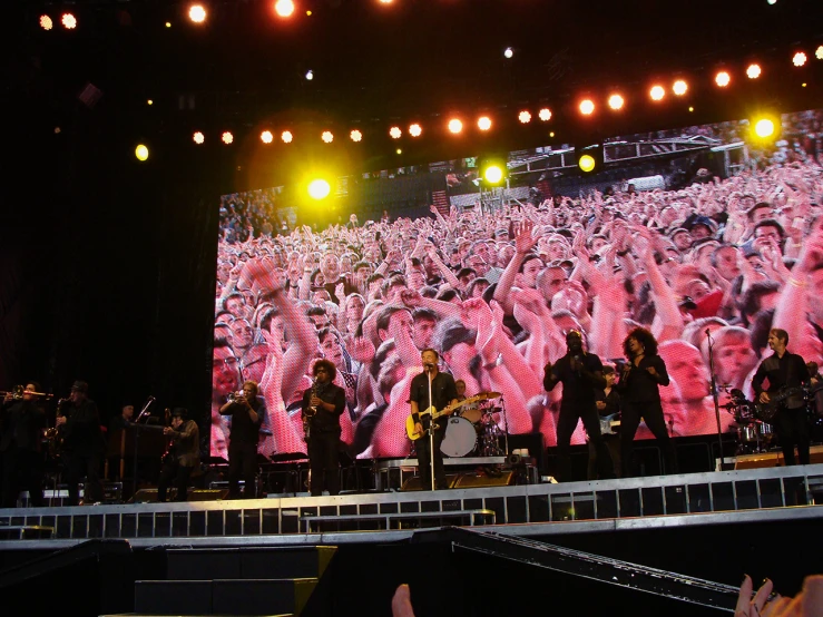 a concert with the theme of a group po projected onto a stage