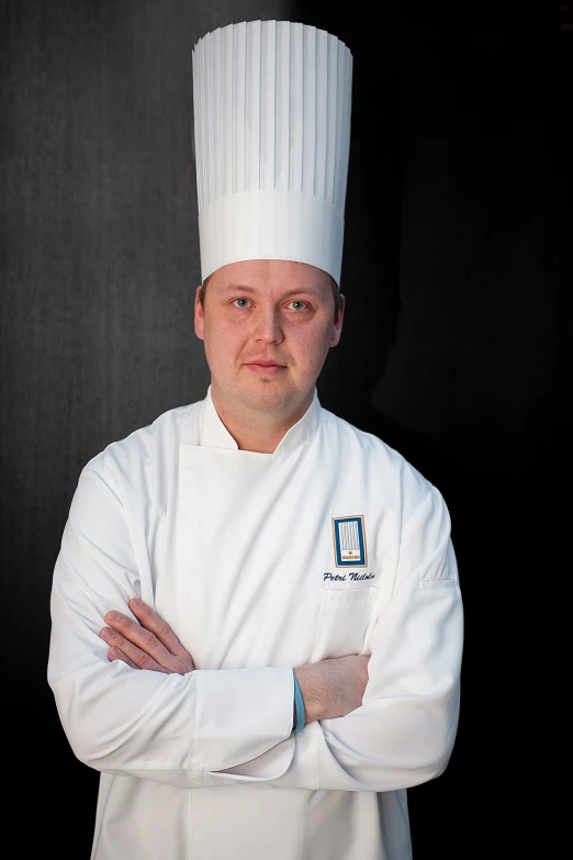 a chef with his arms crossed posing for a po