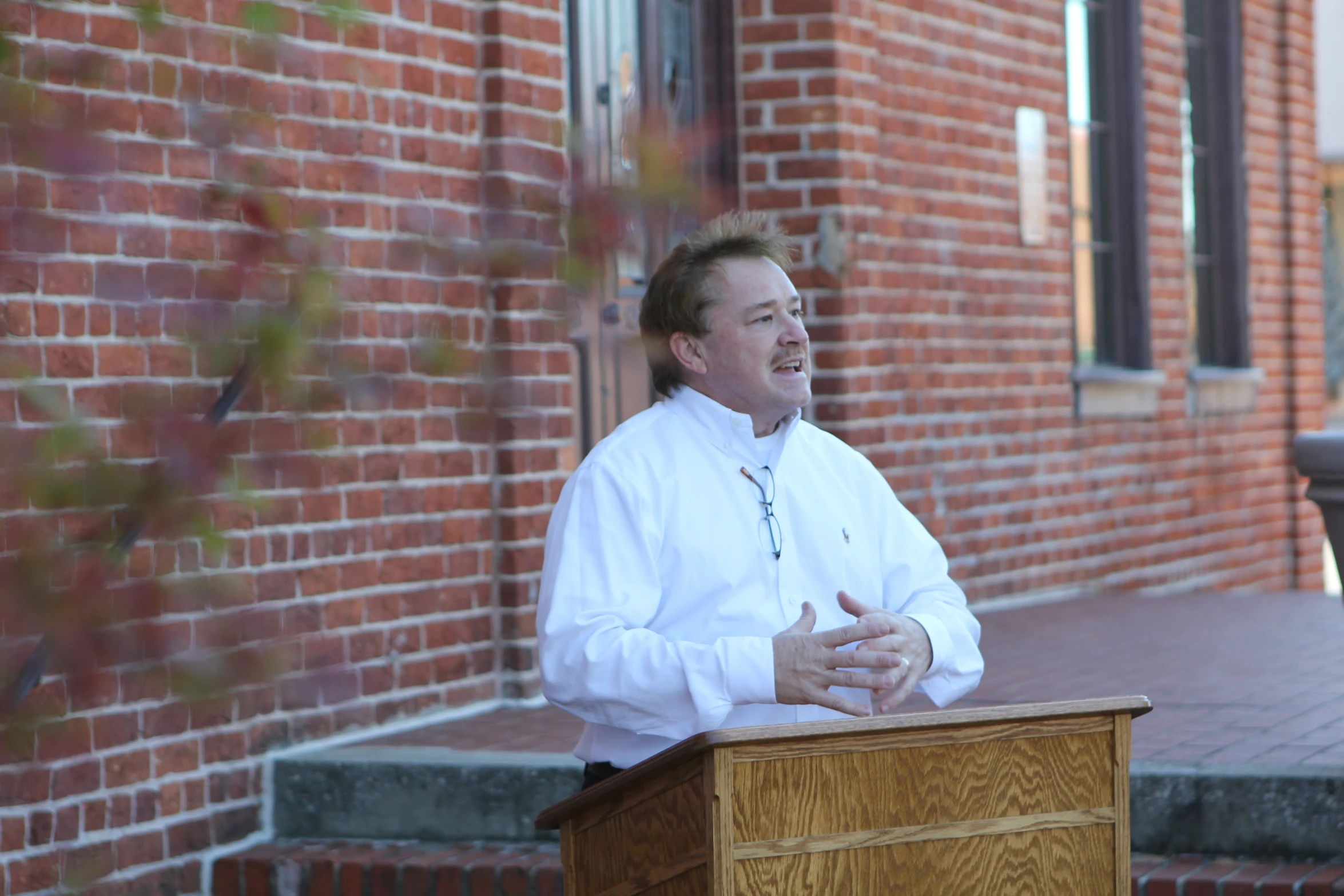 a man wearing a white shirt standing at a podium