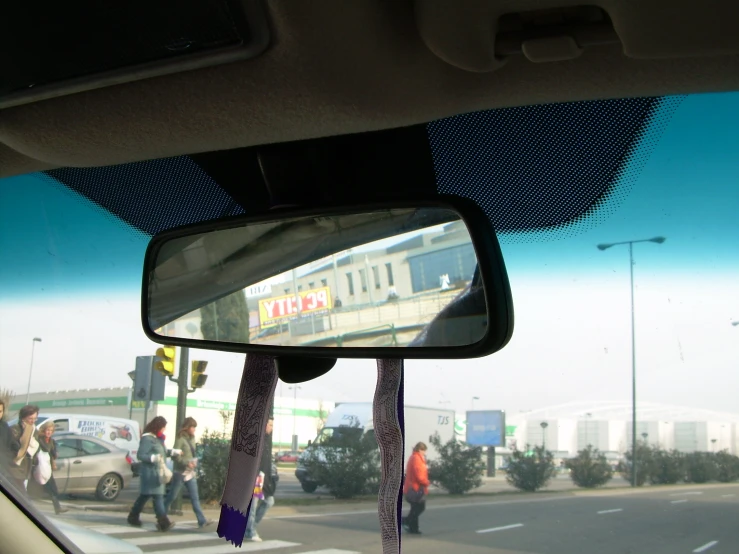 a car view taken through a side mirror as traffic moves down a street