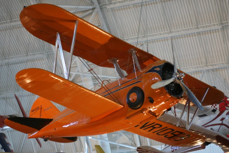 an orange airplane sitting on top of a hangar