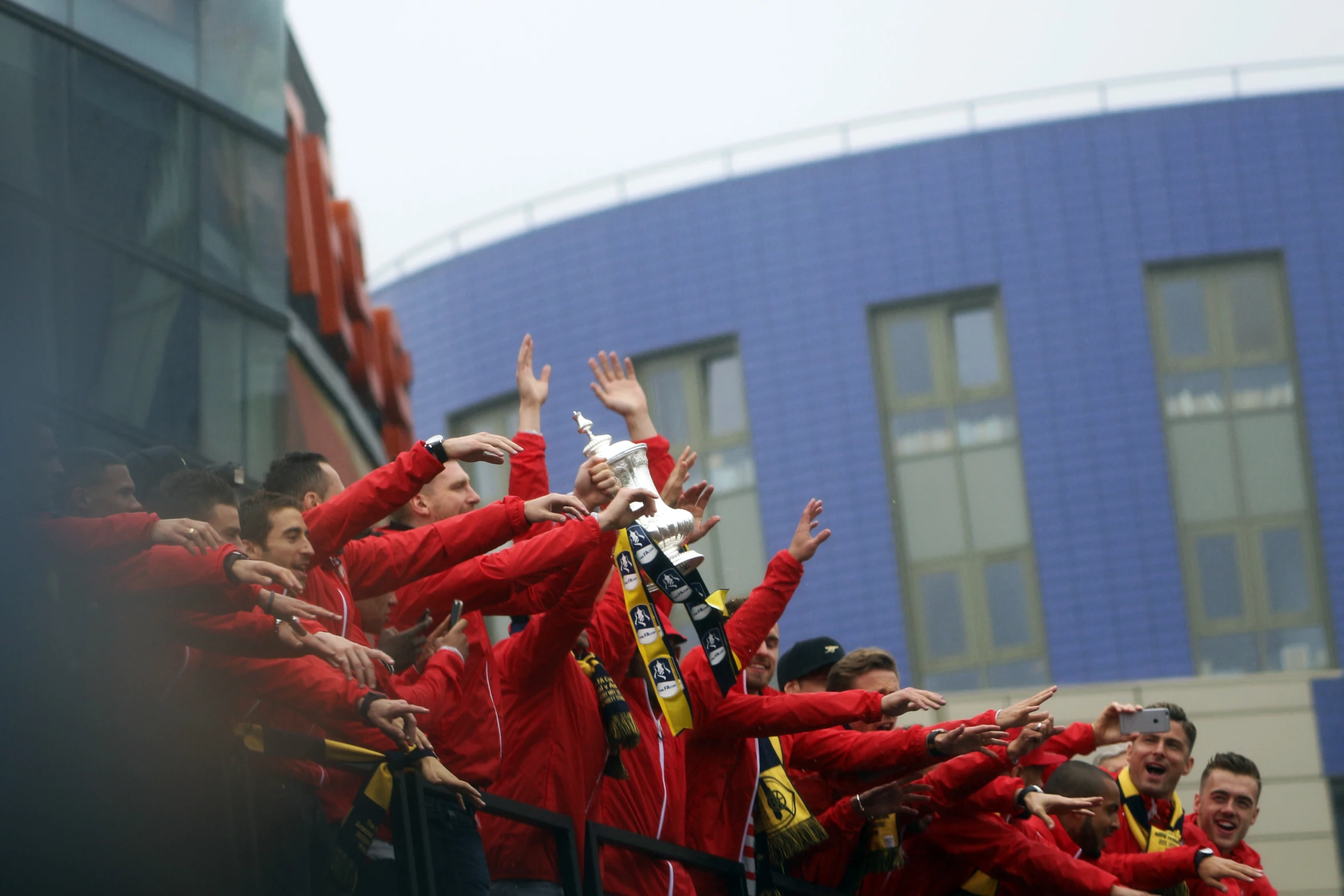 people in red jackets are waving and smiling