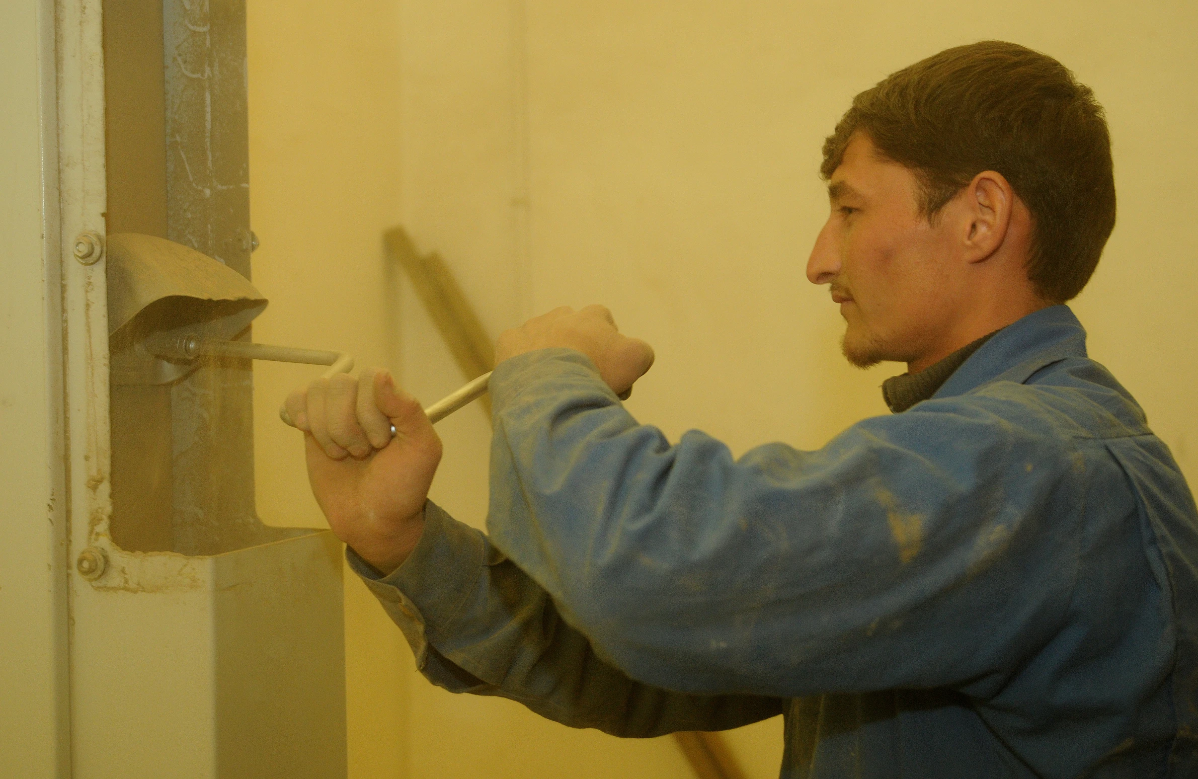 the man is using a hammer on a tile