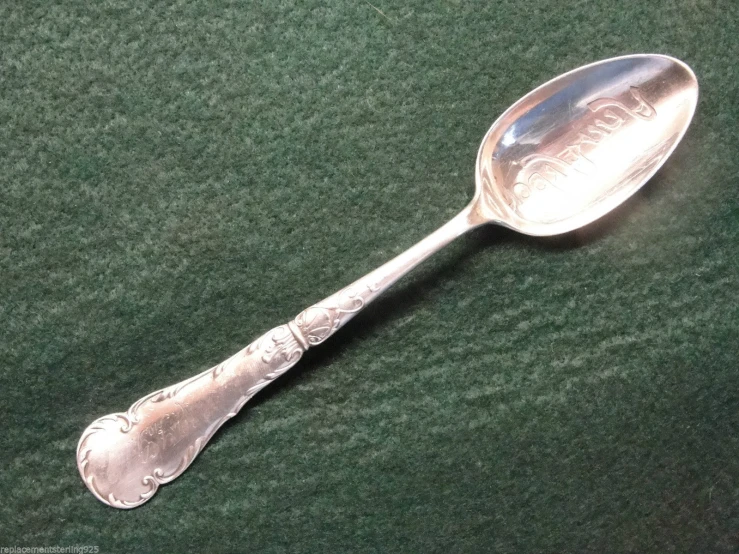 a metal spoon with an ornate engraving on the side