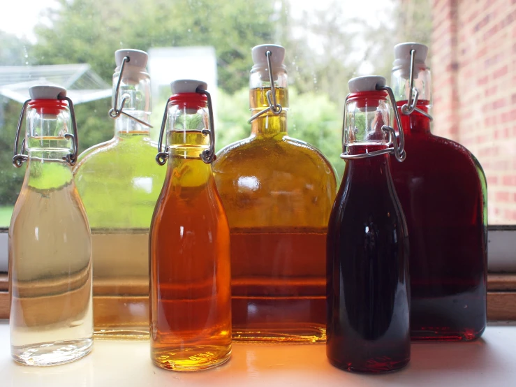 four different colored liquid bottles next to each other