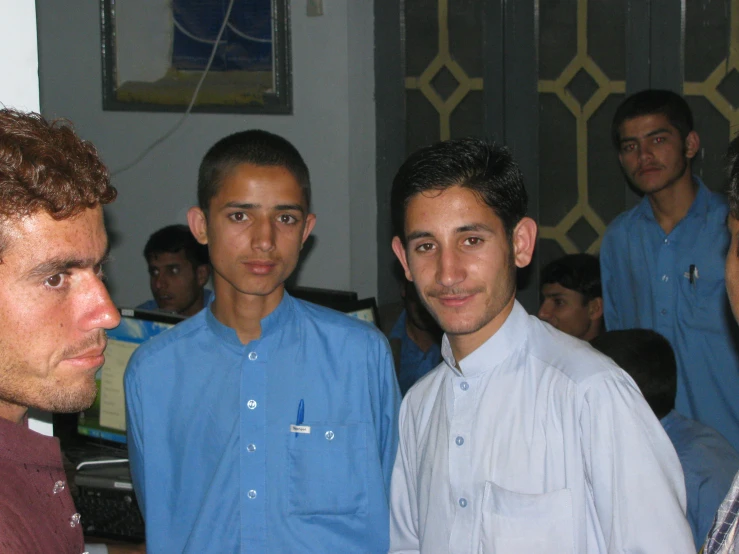 three men stand close together looking at the camera