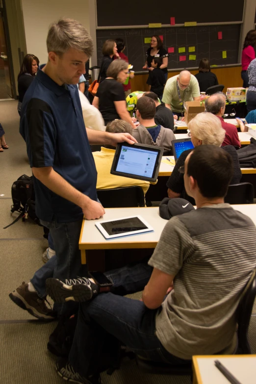 a group of men sitting at a table with laptop computers