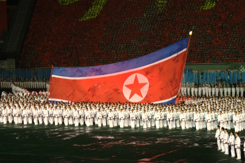 many people are holding flags as the national color scheme is projected on them