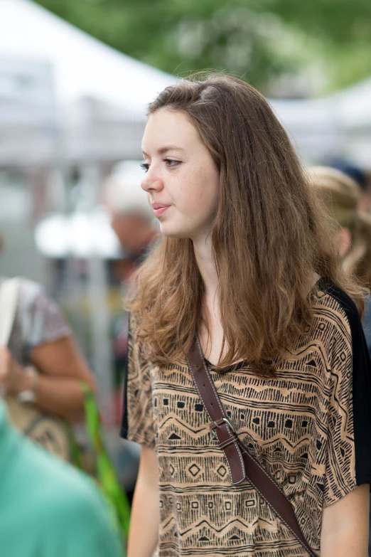 a woman with long hair carrying a bag