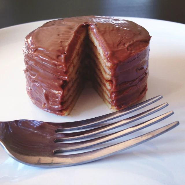 the half eaten cake is shown with chocolate frosting on it