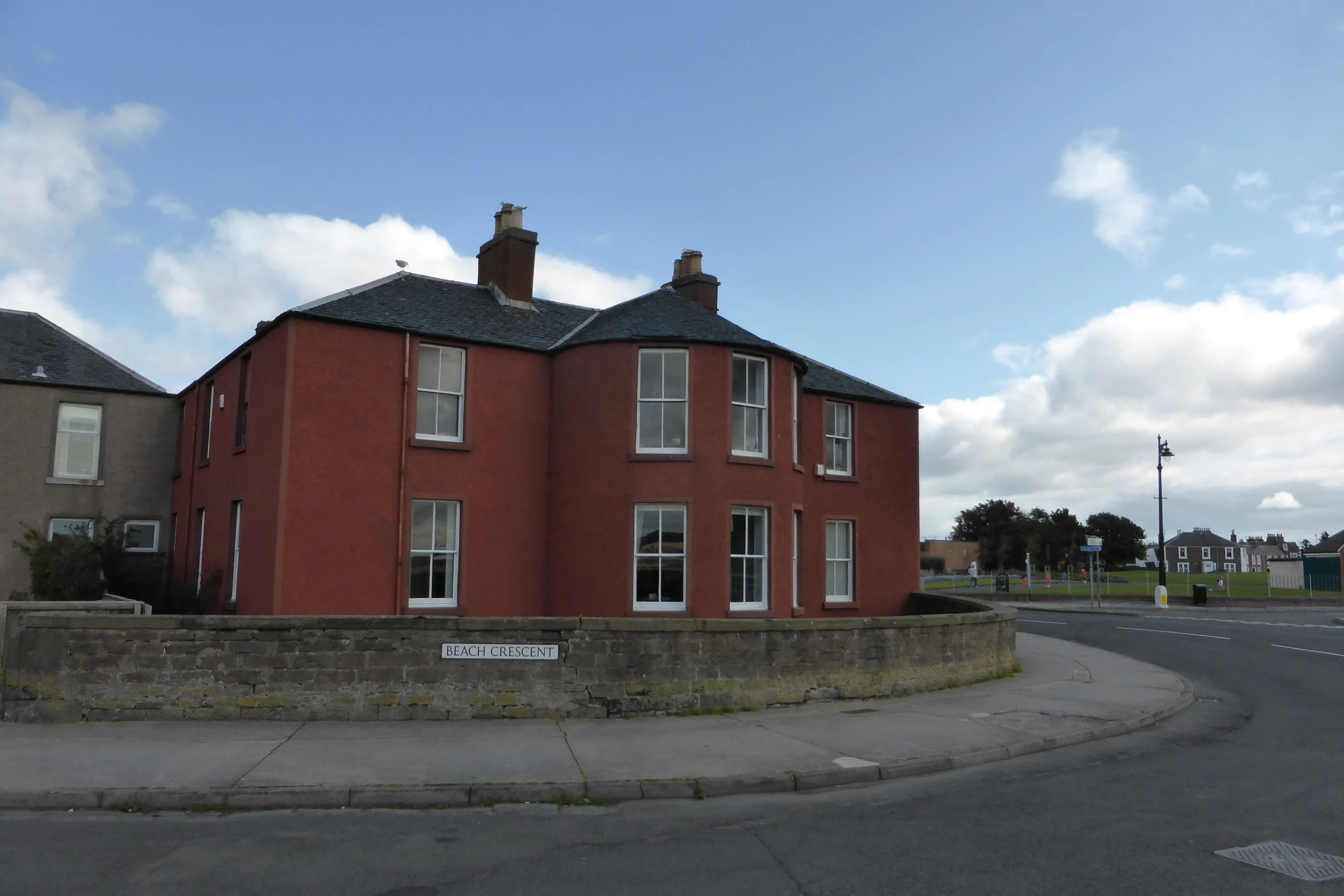 a red house sitting next to an empty road