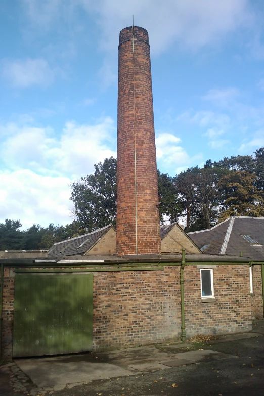 a tower with two clocks next to a green fence