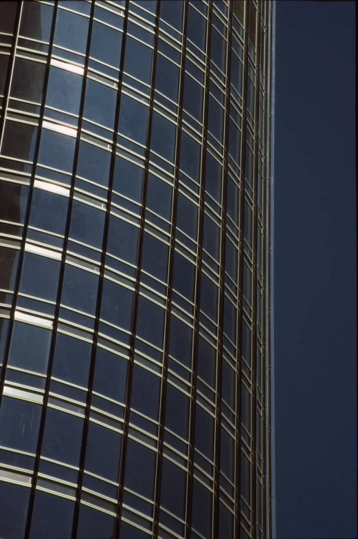 an airplane flying over an abstract building with lots of glass panels
