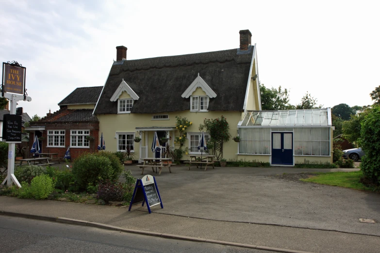 the building has a black thatched roof with white trim