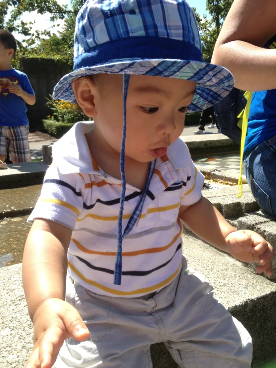 baby playing in playground with parent in background