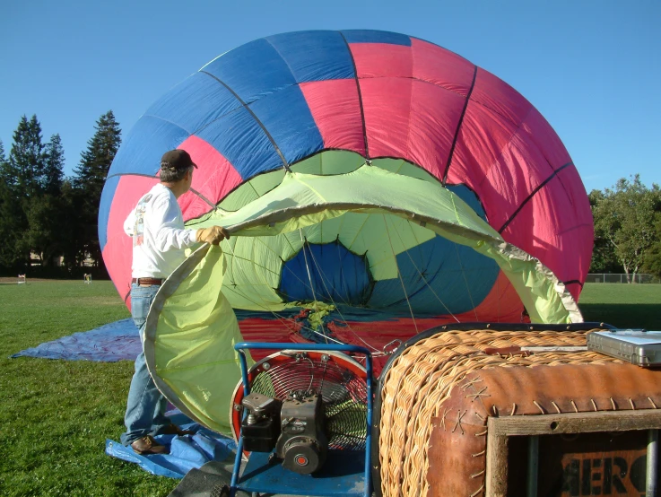 a man working on large colorful air filled balloons