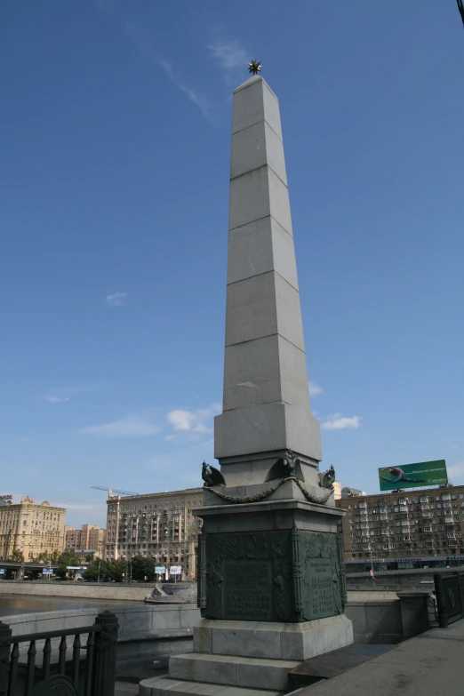 a tall obelisk in a city square with a street sign below it