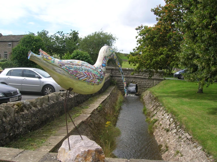 a long bird statue that looks like it has just flown over
