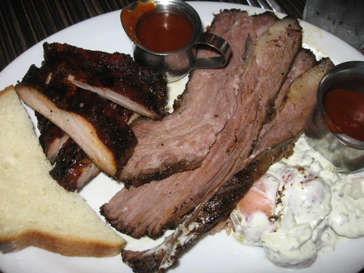 a bbq plate with barbecue ribs, potatoes and salad