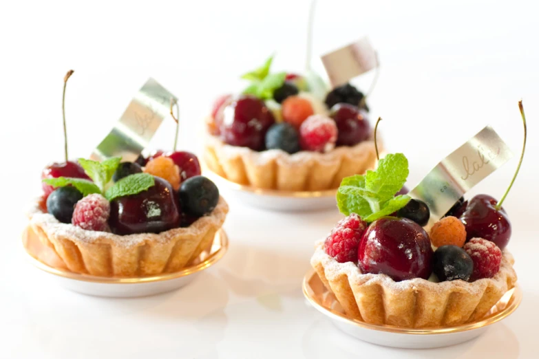 three dessert cups with fruits in them sitting on a table