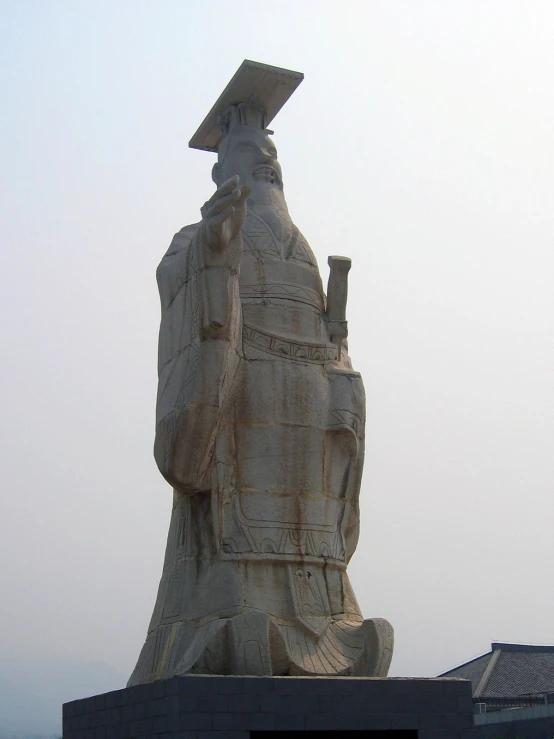 large stone sculpture with large chimney sitting next to building