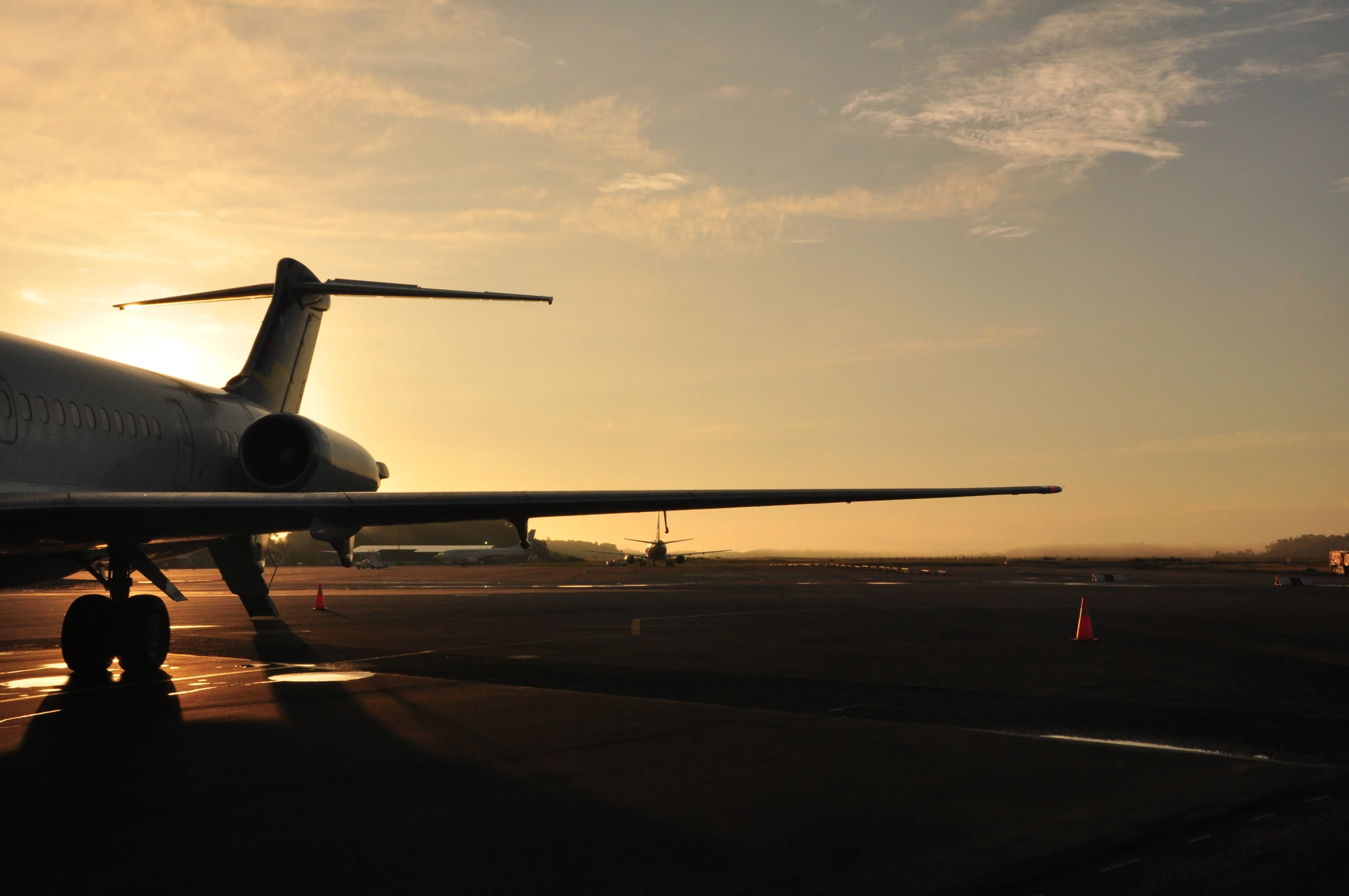 a large plane sitting on the runway at sunset