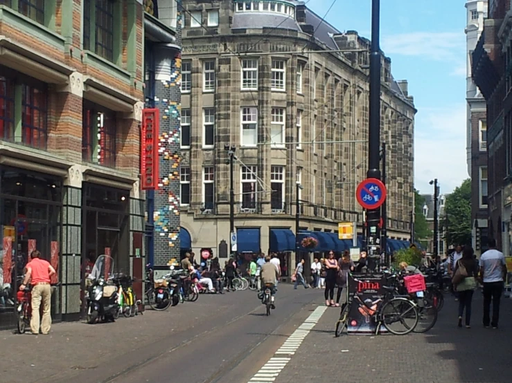 pedestrians and bikes line the street as people walk down it