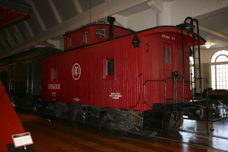 a red caboose sitting on display in a museum