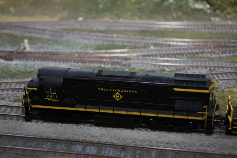 a small black train engine pulling a freight car down a track