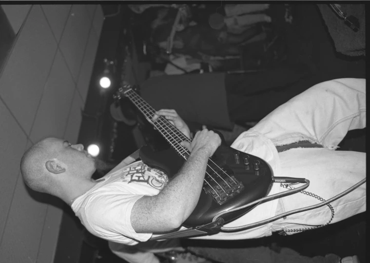 a guy laying on top of another with his guitar