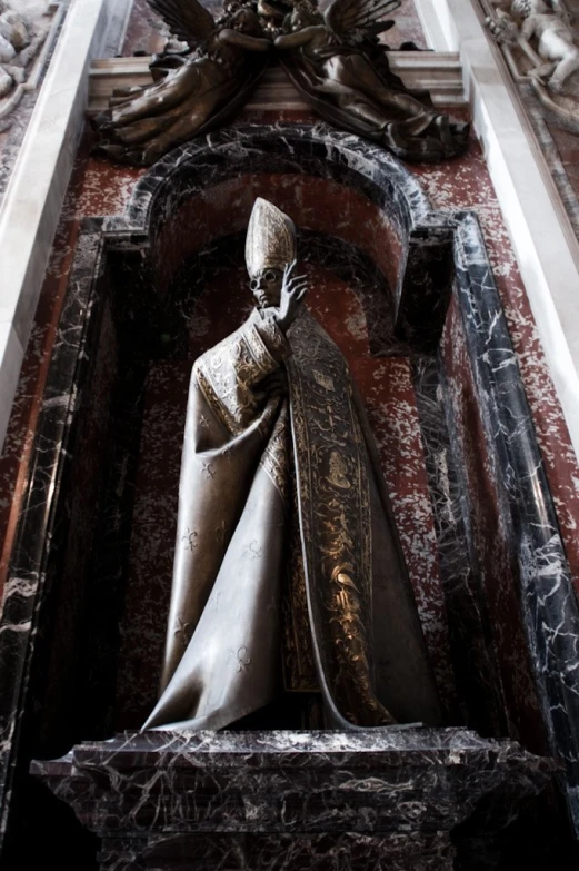 a statue in a room between a wall and an ornate doorway