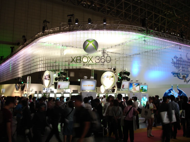 large group of people at an event under a big illuminated sign