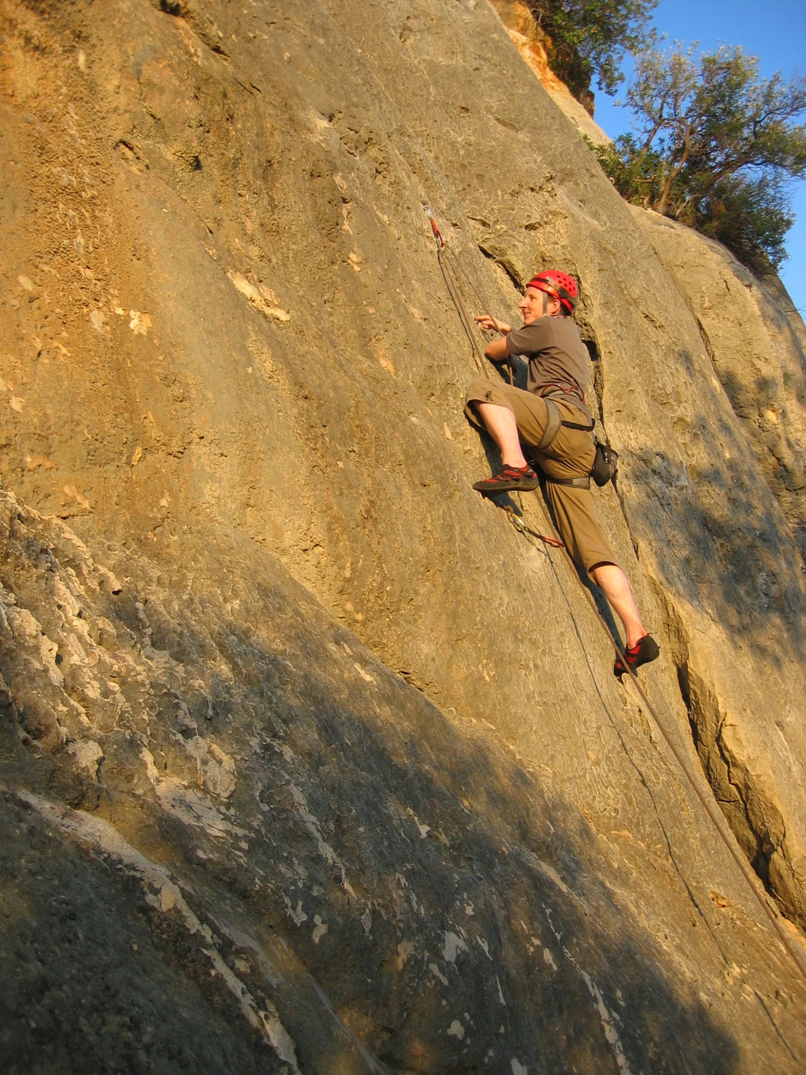 a man is sitting on a ledge on a cliff