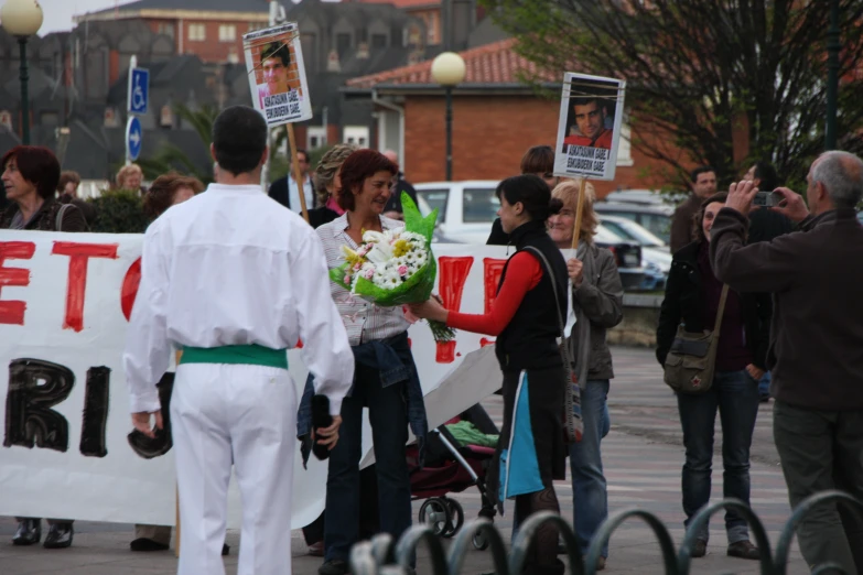 a woman holds a bouquet while walking down the street