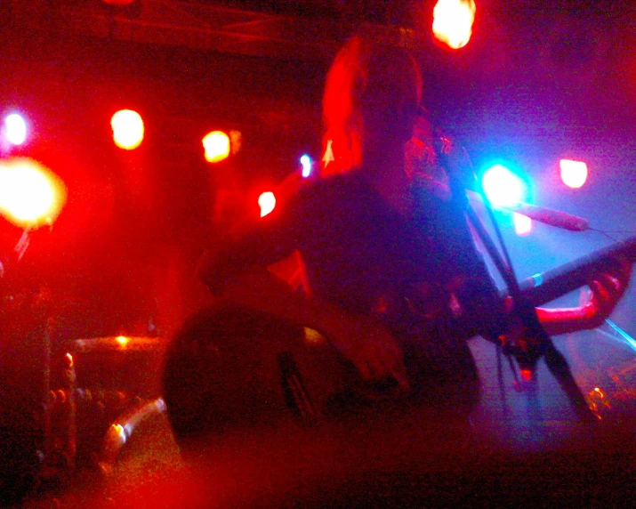 a person on a stool with a microphone in front of red lights