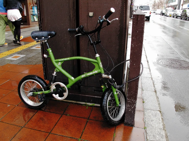 a green bike leaning against a fence on the street