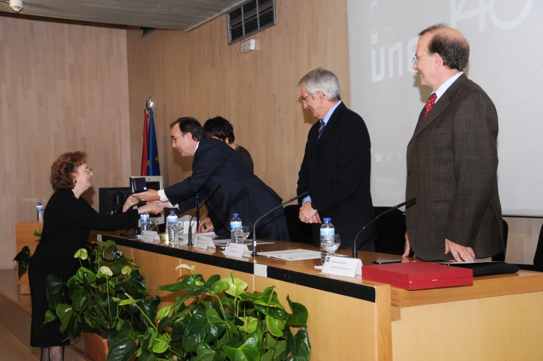 a group of people shake hands at a meeting