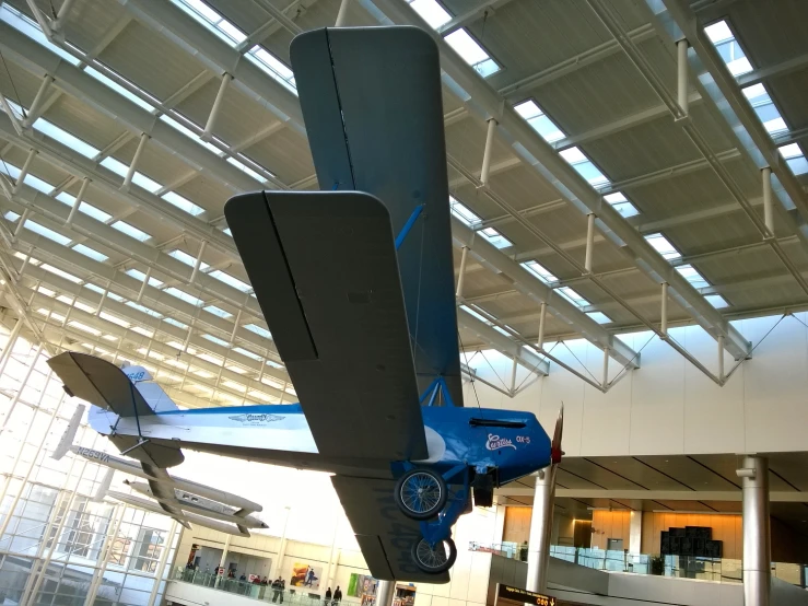 an airplane is hanging in the atrium in a building