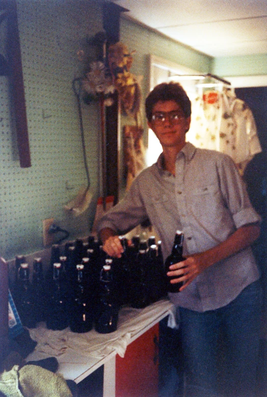 a man standing behind a row of beer bottles