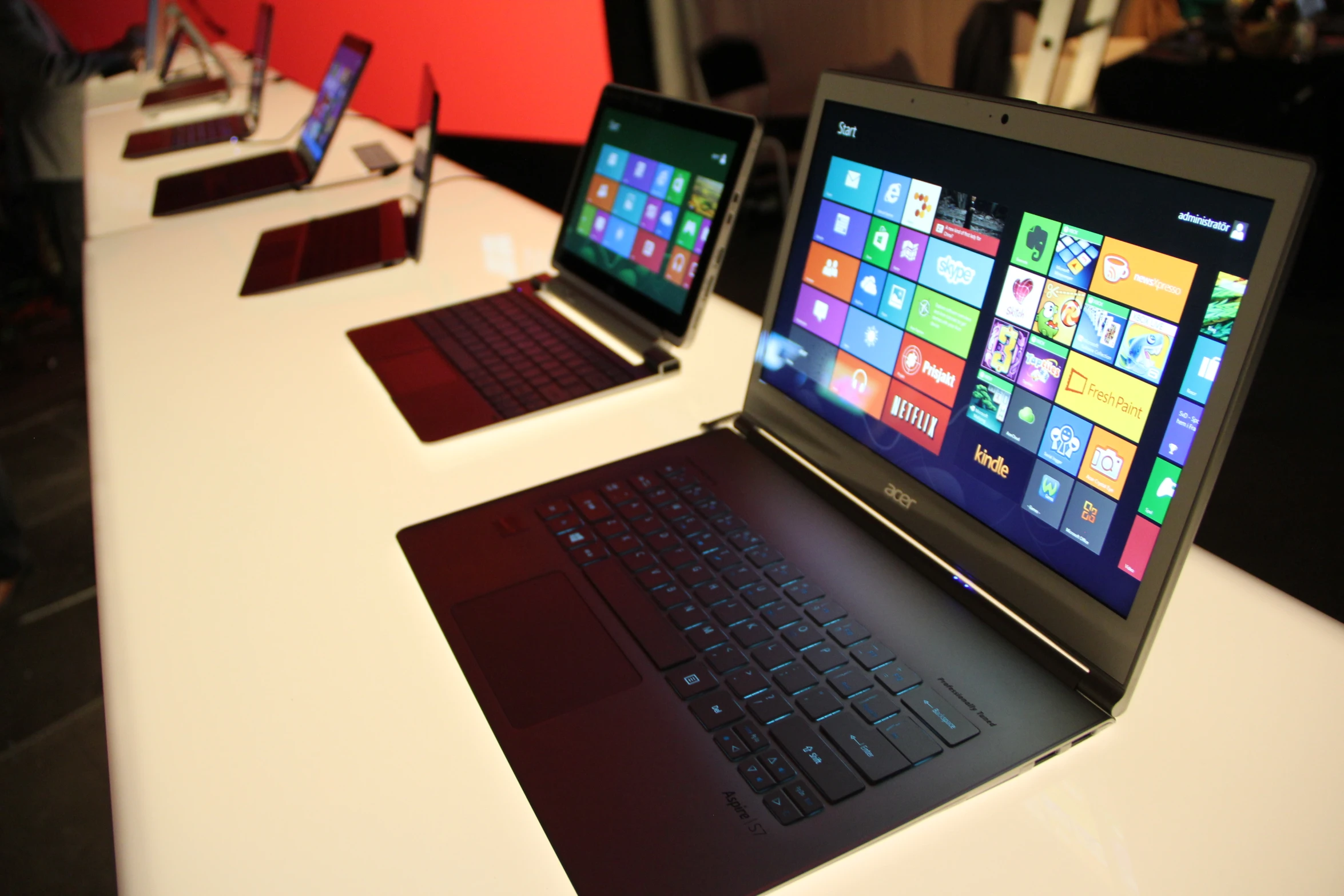 some laptops are on a table and one is on a keyboard