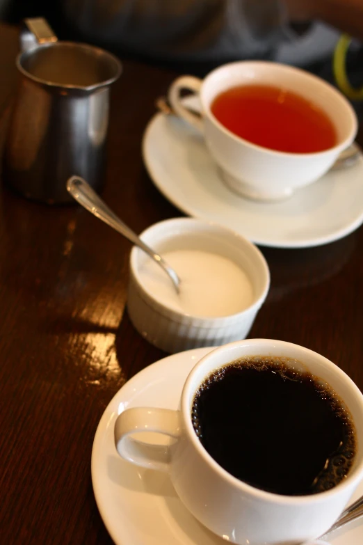 a plate and two cups of coffee sitting on a table