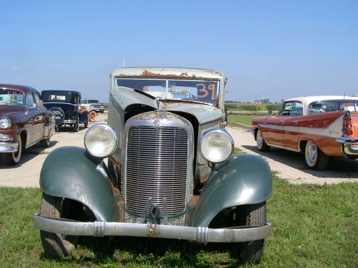 a vintage automobile show with classic cars parked on the field