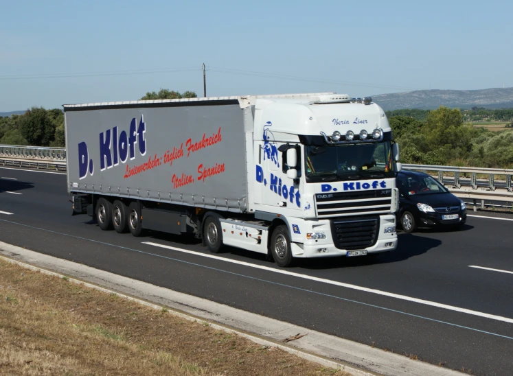 a truck is driving down the highway by a car