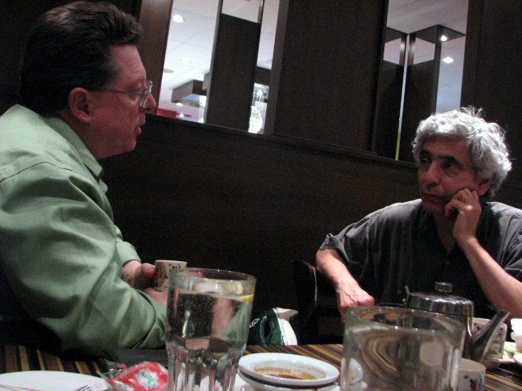 a man in a green shirt is talking to a man