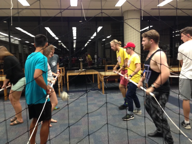 a line of people playing a game in an enclosure