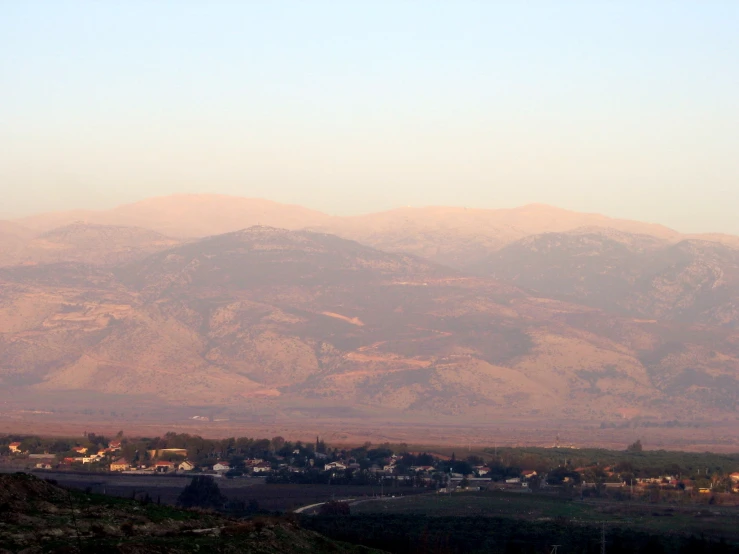 a lone flying bird is in the foreground of the mountains